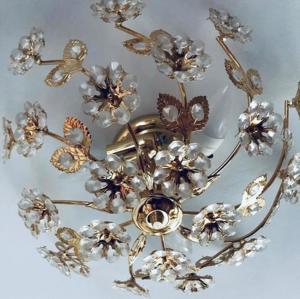 a gold chandelier with flowers on a ceiling at Hotel Daneu Gaschurn in Gaschurn