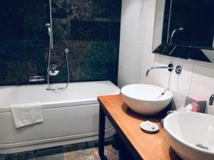 Hotel Daneu Gaschurn في غاسشرن: حمام مع حوض ومرحاض وحوض استحمام