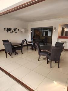 a dining room with black chairs and a table at 17 On Buffalo in Johannesburg