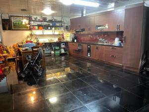 a kitchen with wooden cabinets and a tiled floor at Lee Homestay in Hanoi