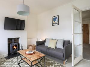 a living room with a couch and a fireplace at Shamrock Cottage in Conwy