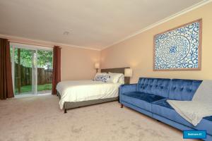 1 dormitorio con 1 cama y 1 sofá azul en NEW! 3-story Townhome - Private, Self checkin, Quiet. en Sterling