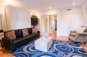 a living room with a black couch and a table at The Luxe Loft 4BR Apartment in NYC! in New York