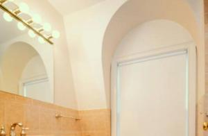 The Luxe Loft 4BR Apartment in NYC! في نيويورك: حمام مع حوض ومرآة وباب