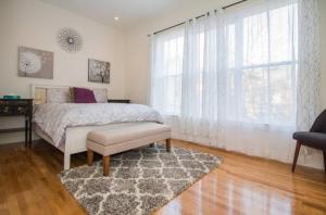 a bedroom with a bed and a window and a rug at The Luxe Loft 4BR Apartment in NYC! in New York