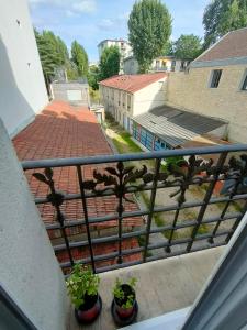 a balcony with potted plants on the ledge of a building at Bel appartement Paris Ouest sur cour proche métro in Boulogne-Billancourt