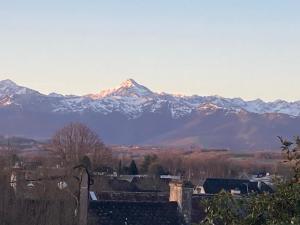 a mountain range with snow covered mountains in the distance at Maison MOKASSI in Laloubère