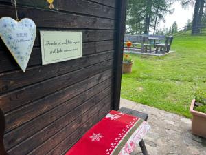 a sign on the side of a house with a bench at Neuwirth Hütte in Gnesau