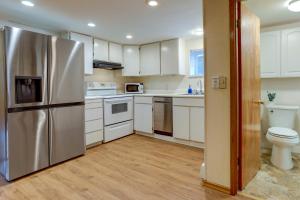een keuken met witte kasten en een roestvrijstalen koelkast bij Charming and Cozy Seattle Apartment with Fireplace! in Seattle