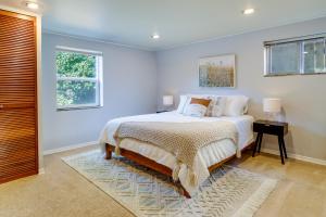 ein weißes Schlafzimmer mit einem Bett und einem Fenster in der Unterkunft Charming and Cozy Seattle Apartment with Fireplace! in Seattle