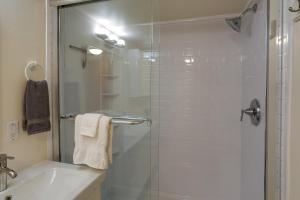 een badkamer met een glazen douche en een wastafel bij Charming and Cozy Seattle Apartment with Fireplace! in Seattle