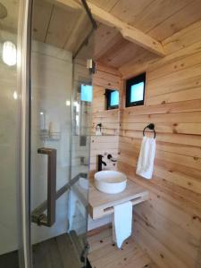 uma casa de banho em madeira com um lavatório e um chuveiro em Bosques del Cielo em Los Lirios