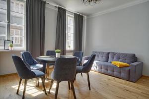 a living room with a couch and a table and chairs at Warsaw Premium Apartments Deluxe Old Town in Warsaw
