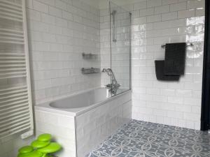 bagno bianco con vasca e doccia di Maison MOKASSI a Laloubère