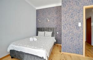 a bedroom with a bed and a blue wall at Warsaw Premium Apartments Deluxe Old Town in Warsaw