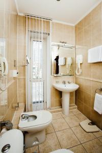 ein Badezimmer mit einem Waschbecken, einem WC und einem Waschbecken in der Unterkunft Business Hotel in Astana