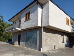 - un bâtiment blanc avec un portail et un balcon dans l'établissement Casa montagna-Parco Maiella-Abruzzo, à Roccamorice