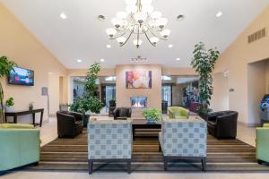 a lobby with tables and chairs and a chandelier at Antioch Hotel & Suites in Antioch