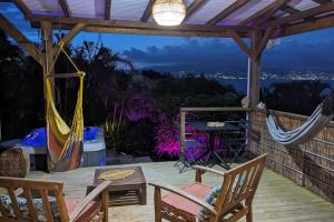 a patio with hammocks and a table and chairs at Cocon de charme avec spa, proche de la plage in Les Trois-Îlets