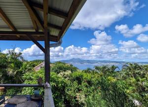 een uitzicht op de oceaan vanaf de veranda van een huis bij Cocon de charme avec spa, proche de la plage in Les Trois-Îlets