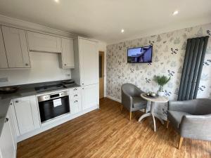 a kitchen with white cabinets and a table and chairs at lodge in the heart of Bourne in Lincolnshire