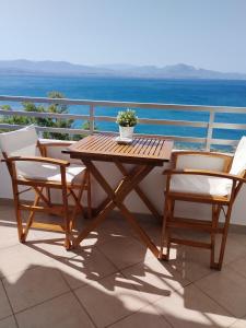 a wooden table and two chairs on a balcony at Atlas-Unlimited Sea View Apartment in Loutraki