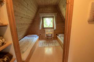 a small attic room with two beds and a window at Ferienhaus Ederer in Waldmünchen
