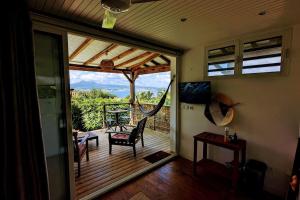 een afgeschermde veranda met uitzicht op een terras bij Cocon de charme avec spa, proche de la plage in Les Trois-Îlets