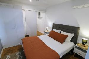a bedroom with a large bed with a orange pillow at Cocon de charme avec spa, proche de la plage in Les Trois-Îlets