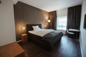 Habitación de hotel con cama y escritorio en Hotel Lindenhof, en Erkelenz