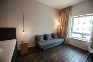 sala de estar con sofá y ventana en Hotel Lindenhof, en Erkelenz