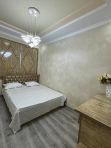 撒馬爾罕的住宿－Apartment BONUSHKA，一间卧室,配有一张床和花瓶