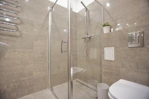 a bathroom with a glass shower with a toilet at Warsaw Premium Apartments Standard Old Town in Warsaw