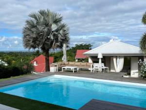 ein Pool vor einem Haus in der Unterkunft Villa Bahia, luxueuse maison d'architecte. in Petit-Bourg