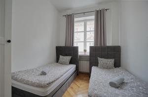 a bedroom with two beds and a window at Warsaw Premium Apartments Standard Old Town in Warsaw