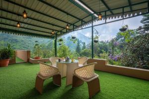 um pátio com uma mesa e cadeiras e uma vista em Sanjwat Homestays Bhimtal - Largest 5BR Luxury Orchard Villa em Bhimtal