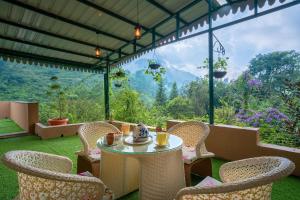 um pátio com uma mesa e cadeiras com vista em Sanjwat Homestays Bhimtal - Largest 5BR Luxury Orchard Villa em Bhimtal