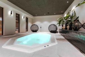 uma grande banheira num quarto com plantas em Hotel Friesenhof em Varel