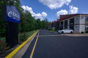 Un coche aparcado en un aparcamiento junto a un edificio. en Excel Inn & Suites, en Fredericksburg