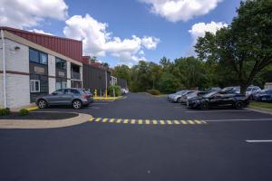 un estacionamiento con autos estacionados al lado de un edificio en Excel Inn & Suites, en Fredericksburg