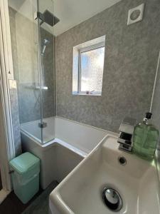 een badkamer met een wastafel, een toilet en een raam bij Entire 3 Bed House in Ipswich in Ipswich