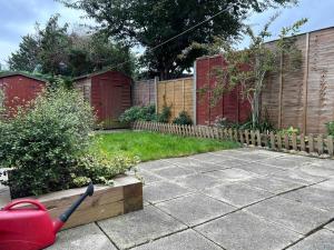 a garden with a fence and a red shovel at Entire 3 Bed House in Ipswich in Ipswich