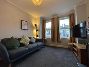 a living room with a couch and a flat screen tv at Entire 3 Bed House in Ipswich in Ipswich