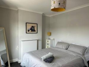 a bedroom with a white bed and a lamp at Entire 3 Bed House in Ipswich in Ipswich