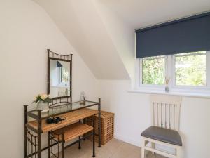 Habitación con espejo, mesa y silla en Castle Cove View, en Weymouth
