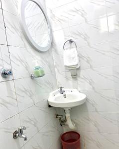 a white bathroom with a sink and a mirror at Pilipili Kijani Luxury homes in Mombasa