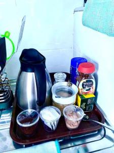 a tray with a coffee maker and other food items at Pilipili Kijani Luxury homes in Mombasa
