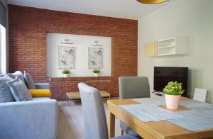 uma sala de estar com uma mesa de jantar e uma parede de tijolos em Warsaw Premium Apartments Old Town Rycerska em Varsóvia