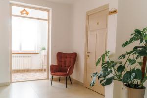 una silla roja en una habitación con una planta en U Progu Lasu en Orzeszkowo