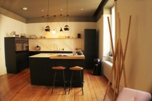 una cocina con una isla con dos taburetes. en Espace Formes d'Art en Belfort